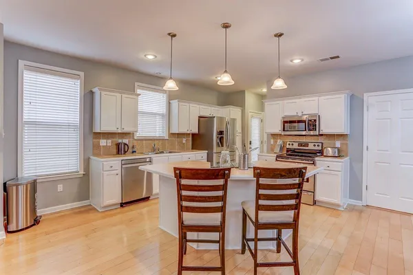a kitchen with stainless steel appliances kitchen island granite top and refrigerator