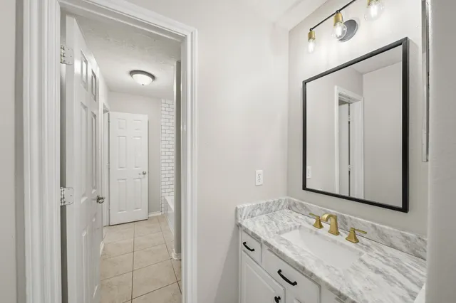 a bathroom with a granite countertop sink vanity and mirror