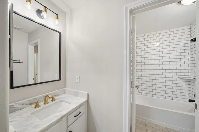 a bathroom with a sink vanity tub and shower