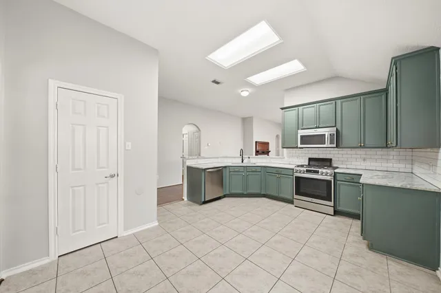 a kitchen with stainless steel appliances a sink and cabinets