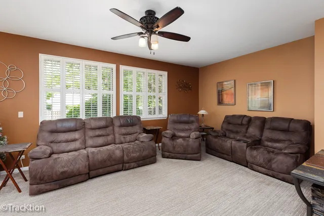 a living room with furniture ceiling fan and a window