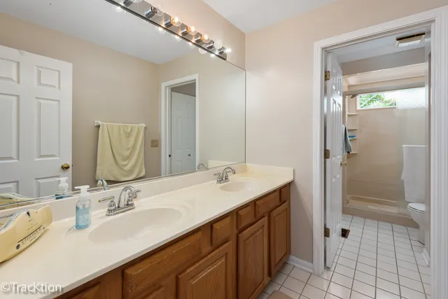 a bathroom with a double vanity sink mirror and shower