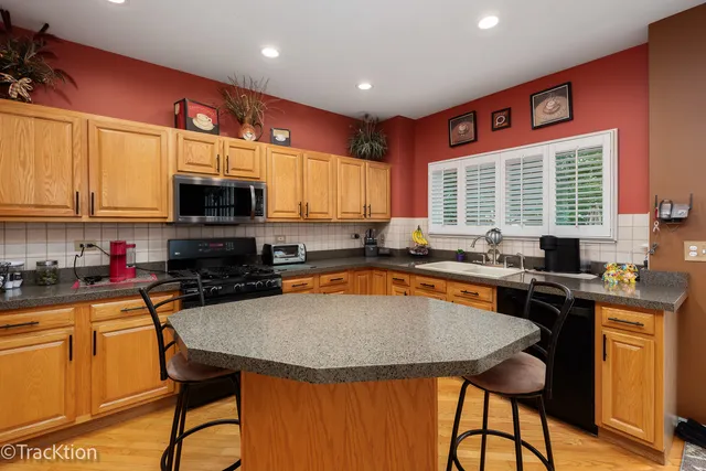 a kitchen with stainless steel appliances a stove a sink a microwave a refrigerator and cabinets