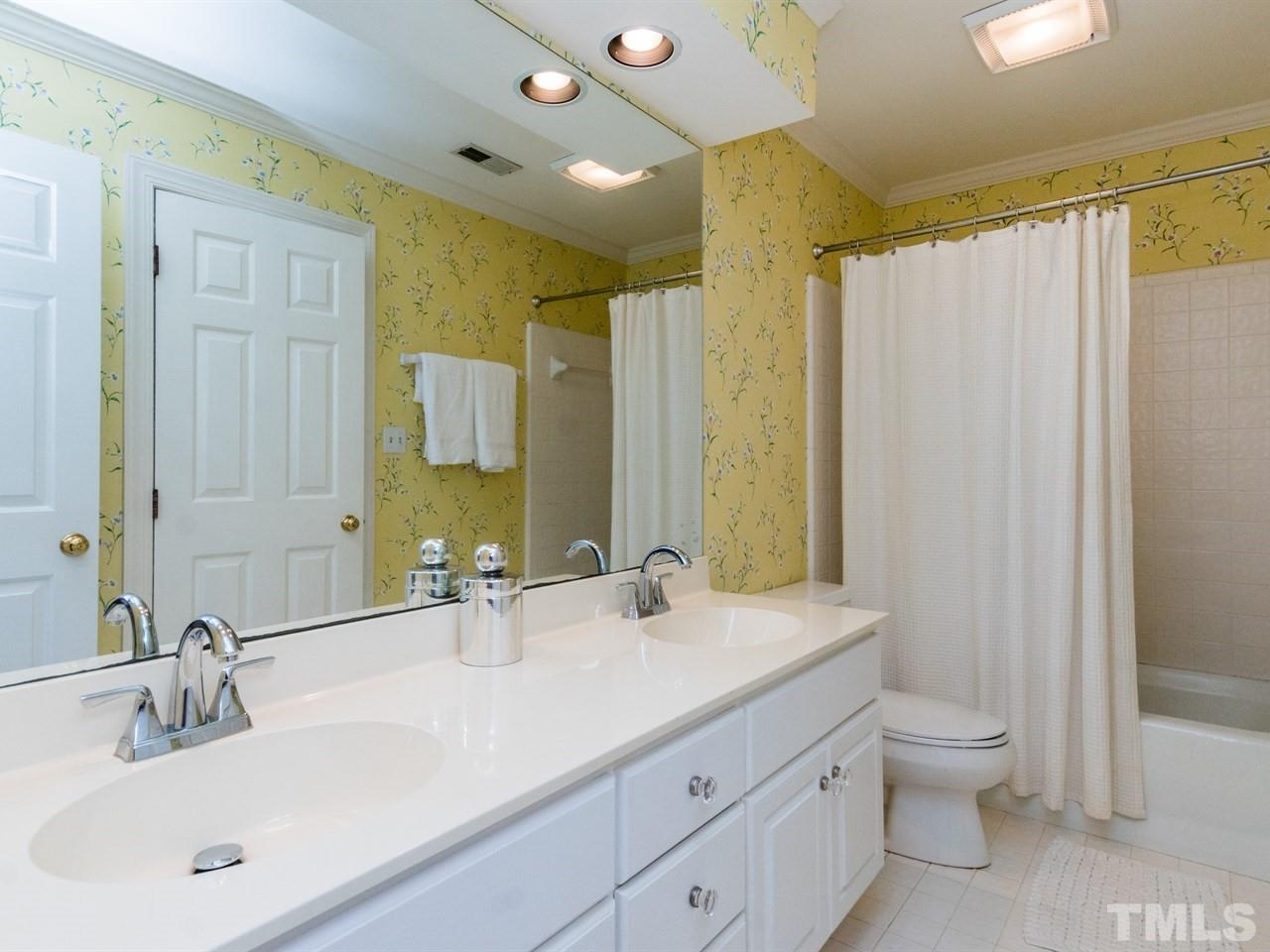 1804 Banbury Road Raleigh, NC 27608 - Photo 20 of 25 a bathroom with a double vanity sink toilet mirror and shower