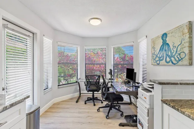 a view of a workspace with furniture and a window