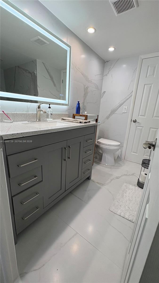 299 Northwest 52nd Terrace, Unit PHX Boca Raton, FL 33487 - Photo 15 of 29 a bathroom with a double vanity sink mirror and bathtub