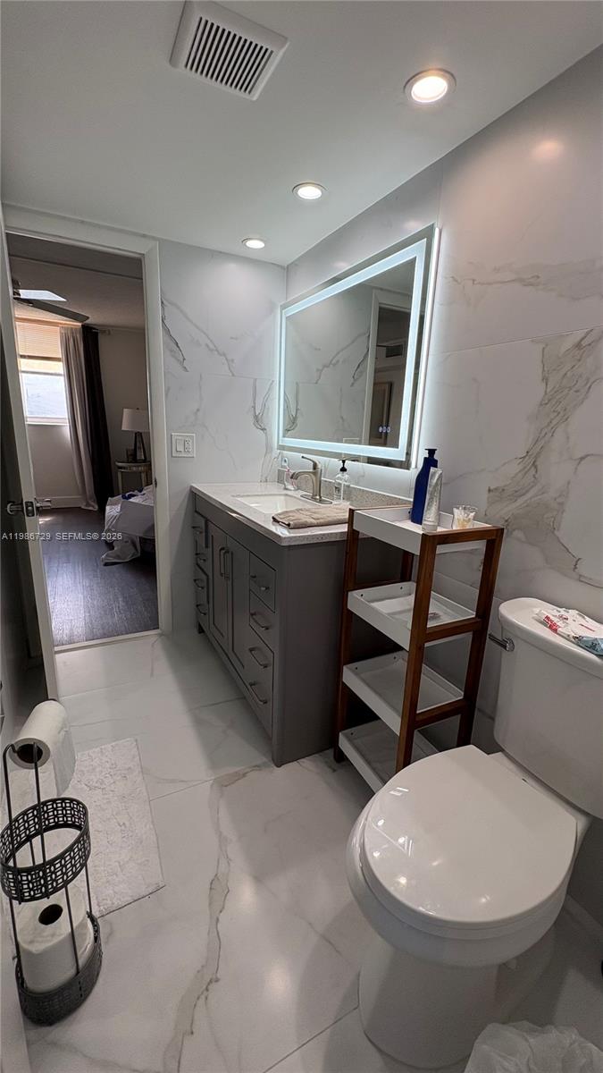 299 Northwest 52nd Terrace, Unit PHX Boca Raton, FL 33487 - Photo 16 of 29 a bathroom with a toilet sink and mirror