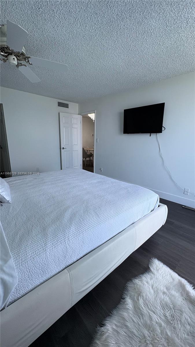 299 Northwest 52nd Terrace, Unit PHX Boca Raton, FL 33487 - Photo 2 of 29 a large bed sitting in a bedroom and wooden floor