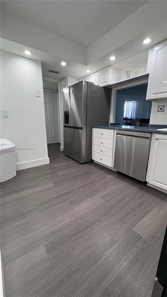 299 Northwest 52nd Terrace, Unit PHX Boca Raton, FL 33487 - Photo 9 of 29 a view of kitchen with stainless steel appliances wooden floor and chair