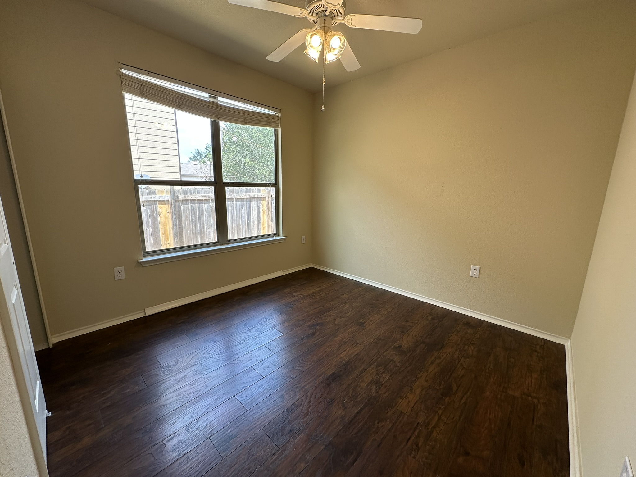 4507 Peach Grove Road Austin, TX 78744 - Photo 23 of 35 Rich dark wood flooring contrasts beautifully against neutral walls and a large window.