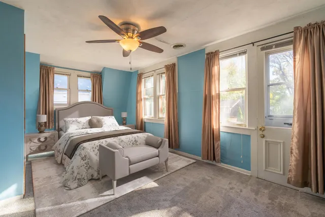 a spacious bedroom with a large bed and a chandelier