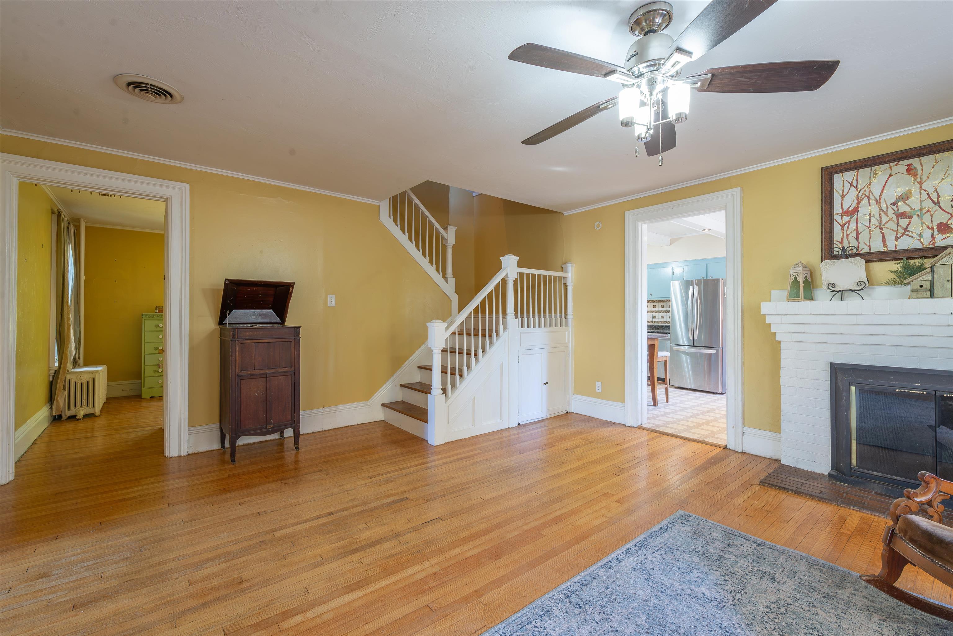 933 West Stephenson Street Freeport, IL 61032 - Photo 6 of 32 a view of a livingroom with wooden floor a ceiling fan and a kitchen