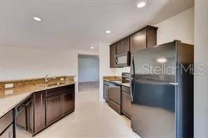 a kitchen with stainless steel appliances granite countertop a refrigerator and a stove