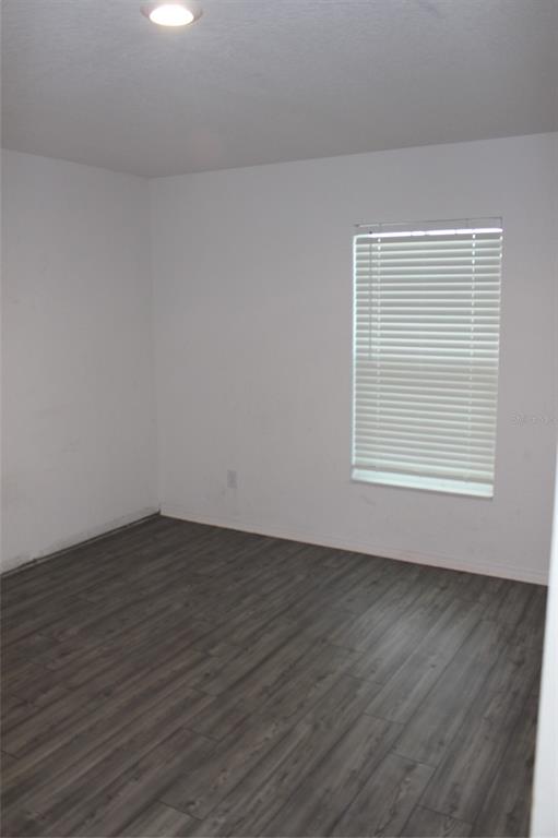 1733 Canaan Loop Dundee, FL 33838 - Photo 9 of 16 a view of an empty room with wooden floor and a window