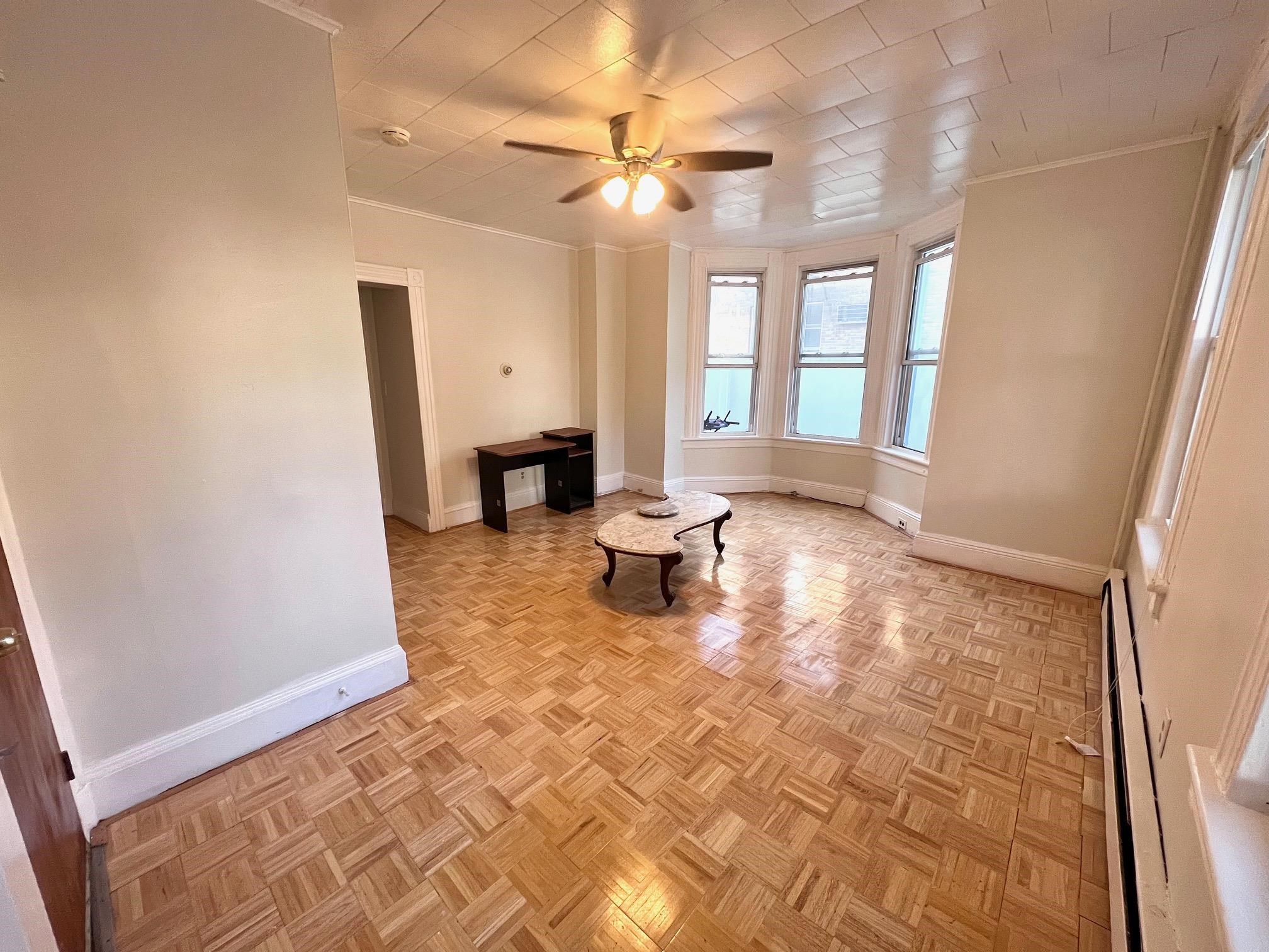 177 Park Avenue, Unit 2 East Rutherford, NJ 07073 - Photo 2 of 7 a living room with a fireplace furniture a ceiling fan and a rug