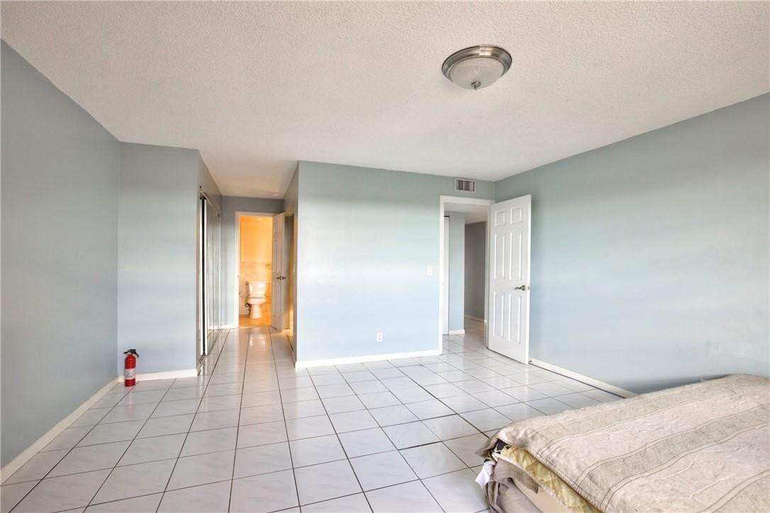 22605 Southwest 66th Avenue, Unit 401 Boca Raton, FL 33428 - Photo 8 of 29 a spacious bedroom with a bed and a window