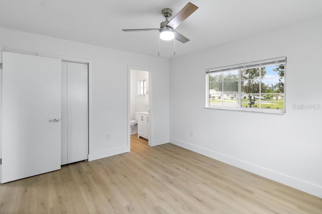 7579 Southwest 108th Place Ocala, FL 34476 - Photo 13 of 33 a view of an empty room with wooden floor and a ceiling fan