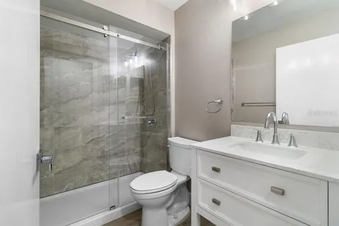 a bathroom with a sink a toilet and shower