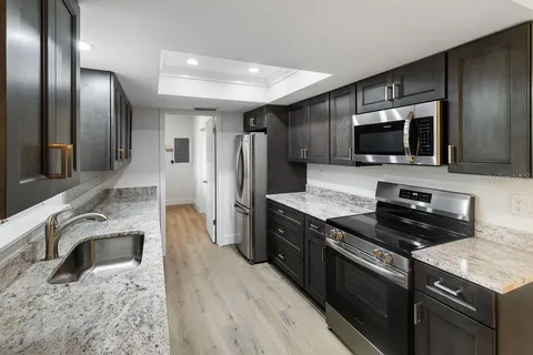 a kitchen with granite countertop stainless steel appliances and wooden cabinets
