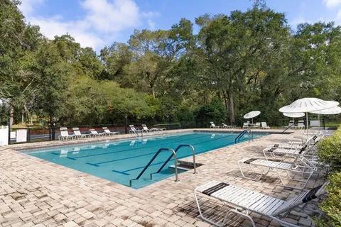 a view of a swimming pool with a patio and a yard