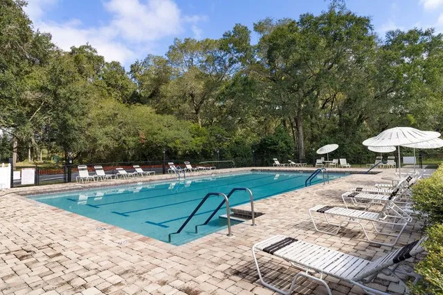 a view of a swimming pool with a patio and a yard