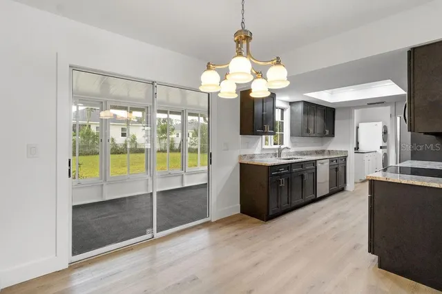 a large kitchen with a counter space a sink and stainless steel appliances