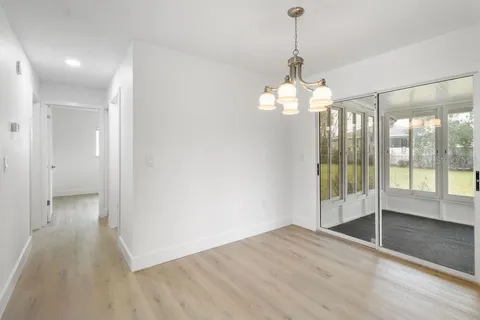 a view of a room with wooden floor fan and windows