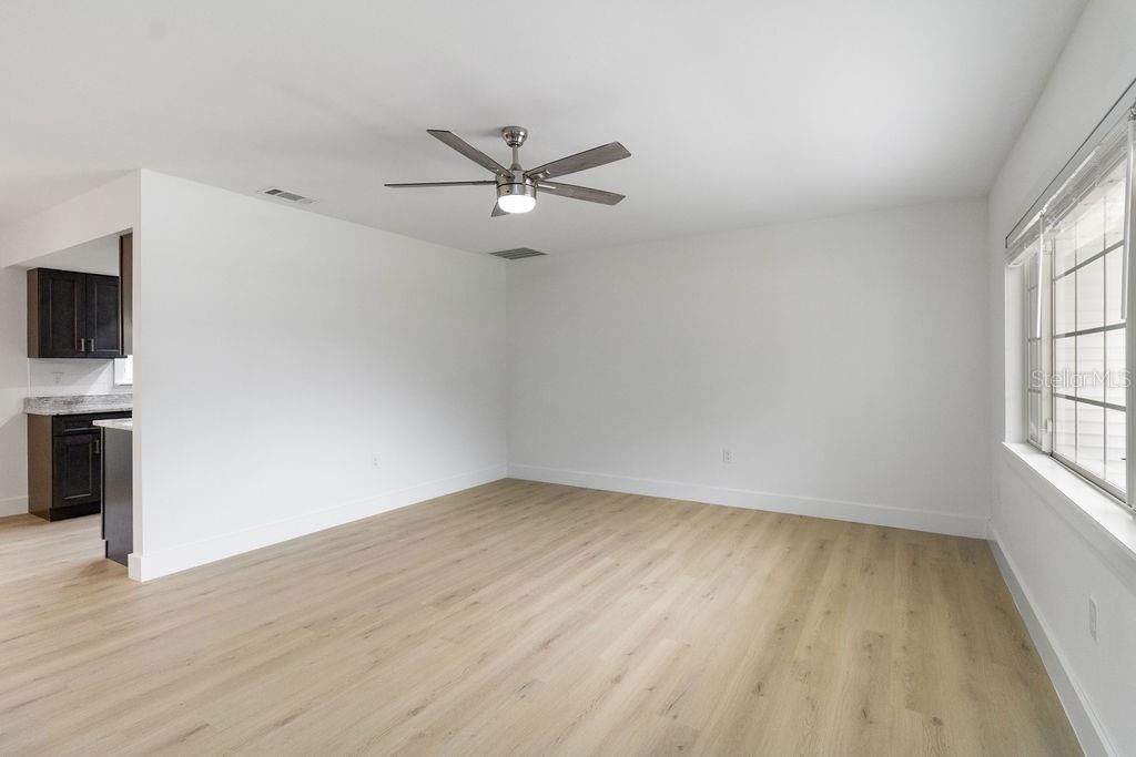 7579 Southwest 108th Place Ocala, FL 34476 - Photo 6 of 33 an empty room with wooden floor fan and windows