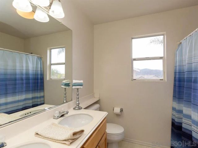 a bathroom with a sink vanity granite and toilet