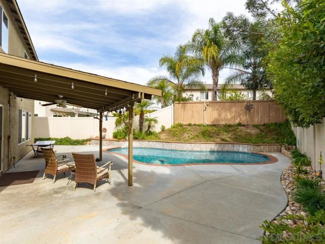 a view of swimming pool with outdoor seating and a patio