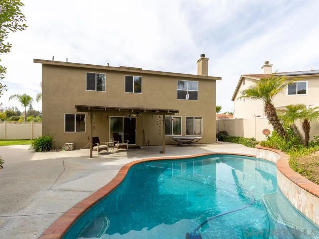 a view of a house with swimming pool and sitting area