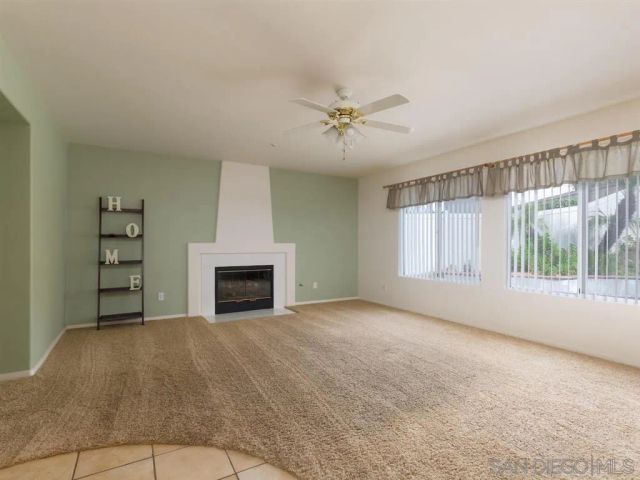 a view of empty room with fireplace and windows