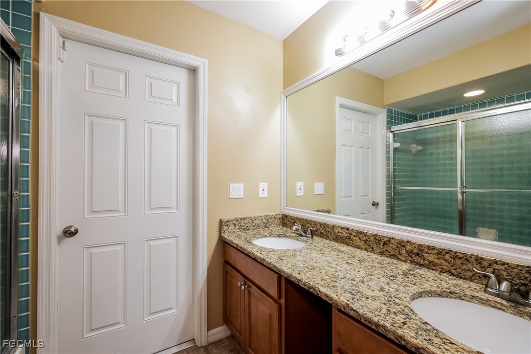 803 Hamilton Avenue Lehigh Acres, FL 33972 - Photo 11 of 16 a bathroom with a granite countertop sink and a mirror