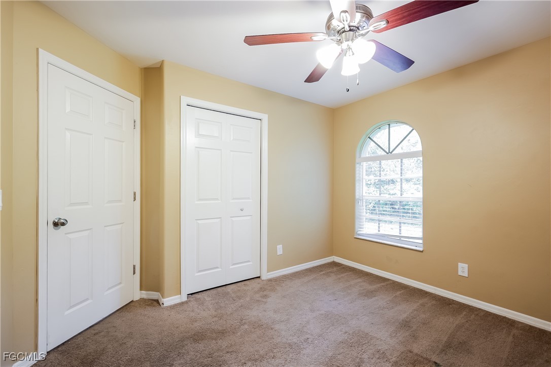 803 Hamilton Avenue Lehigh Acres, FL 33972 - Photo 12 of 16 an empty room with windows and chandelier fan