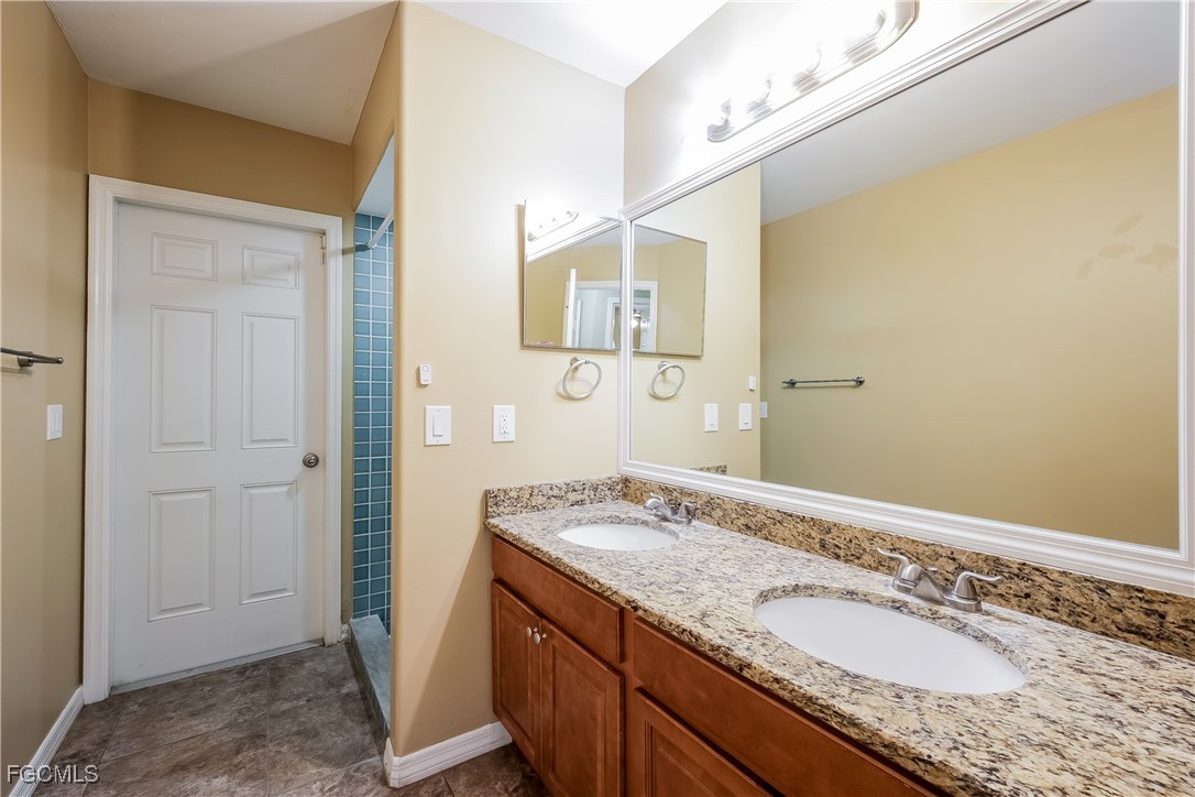 803 Hamilton Avenue Lehigh Acres, FL 33972 - Photo 13 of 16 a bathroom with a granite countertop sink and a mirror
