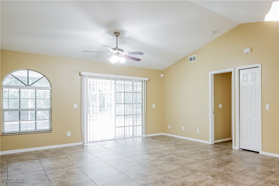 803 Hamilton Avenue Lehigh Acres, FL 33972 - Photo 3 of 16 an empty room with windows and chandelier fan