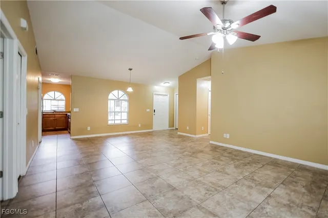 a view of an empty room and a chandelier fan