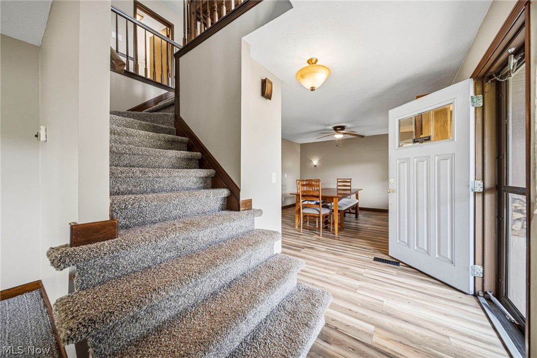 10610 Ridgewater Drive Painesville, OH 44077 - Photo 5 of 23 Carpeted staircase with dark wood newel posts and banister