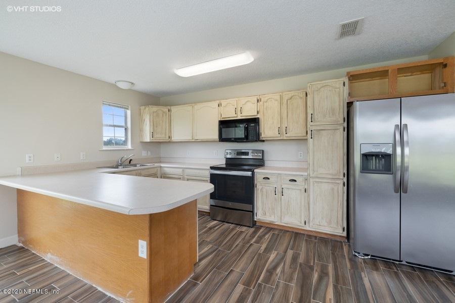 11101 Aaron Fish Road Glen St. Mary, FL 32040 - Photo 8 of 44 a kitchen with stainless steel appliances granite countertop a sink stove and refrigerator