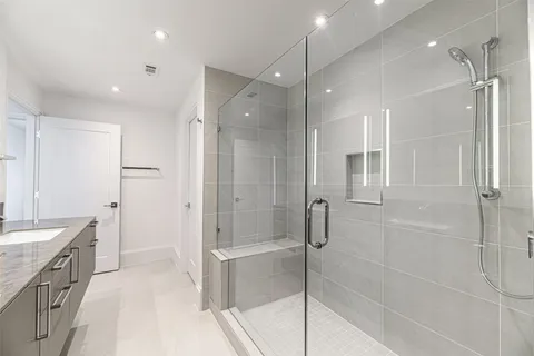 a bathroom with a shower sink vanity and a mirror