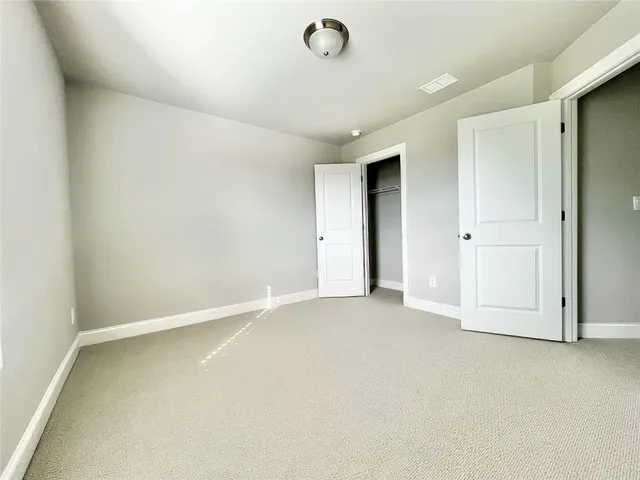 an empty room with closet area and chandelier fan