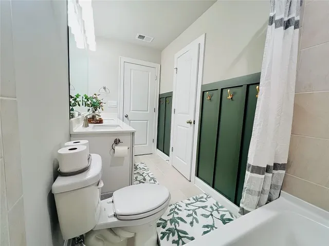 a white toilet sitting next to a bathroom sink and a mirror