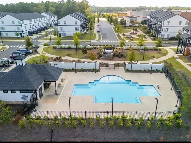 an aerial view of residential houses with outdoor space and parking