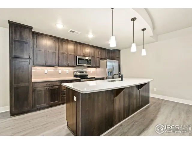 a kitchen with stainless steel appliances granite countertop a sink a stove and a refrigerator