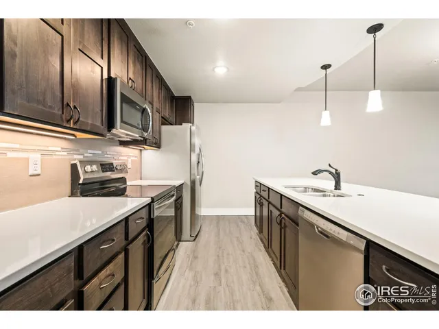 a kitchen with stainless steel appliances granite countertop a sink a stove and a microwave