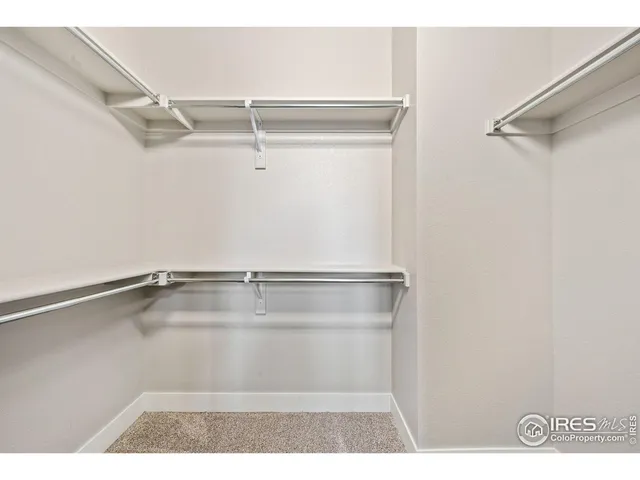 an empty room with closet and ceiling fan