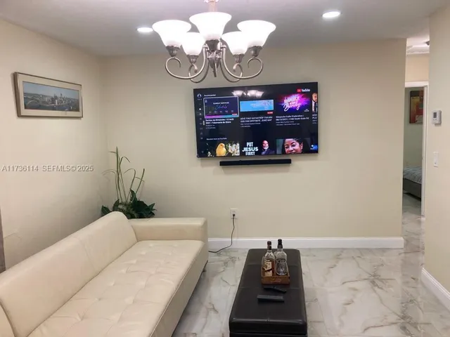 a living room with furniture and a chandelier