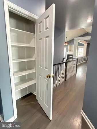 a view of a hallway with wooden floor and entryway