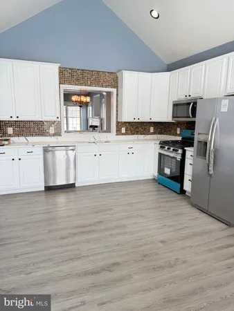 a kitchen with granite countertop a refrigerator stove top oven and sink