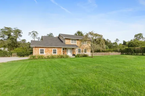 a view of a big yard with a house in the background